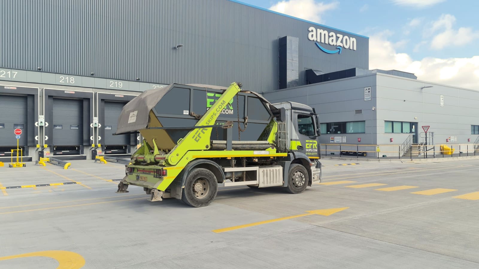 An EFR Skips lorry delivering a 16 yard skip to an Amazon site