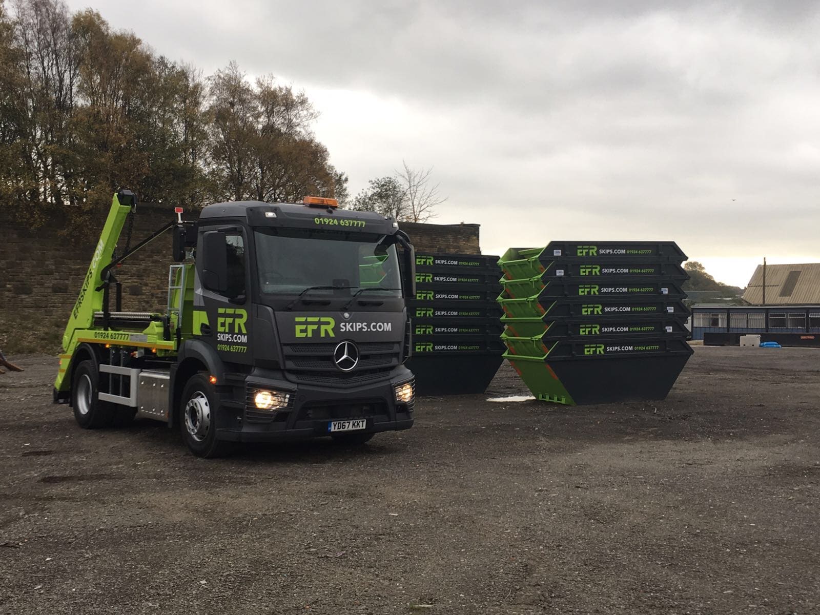 EFR Skips delivery lorry alongside stacks of bright-green skips at our yard